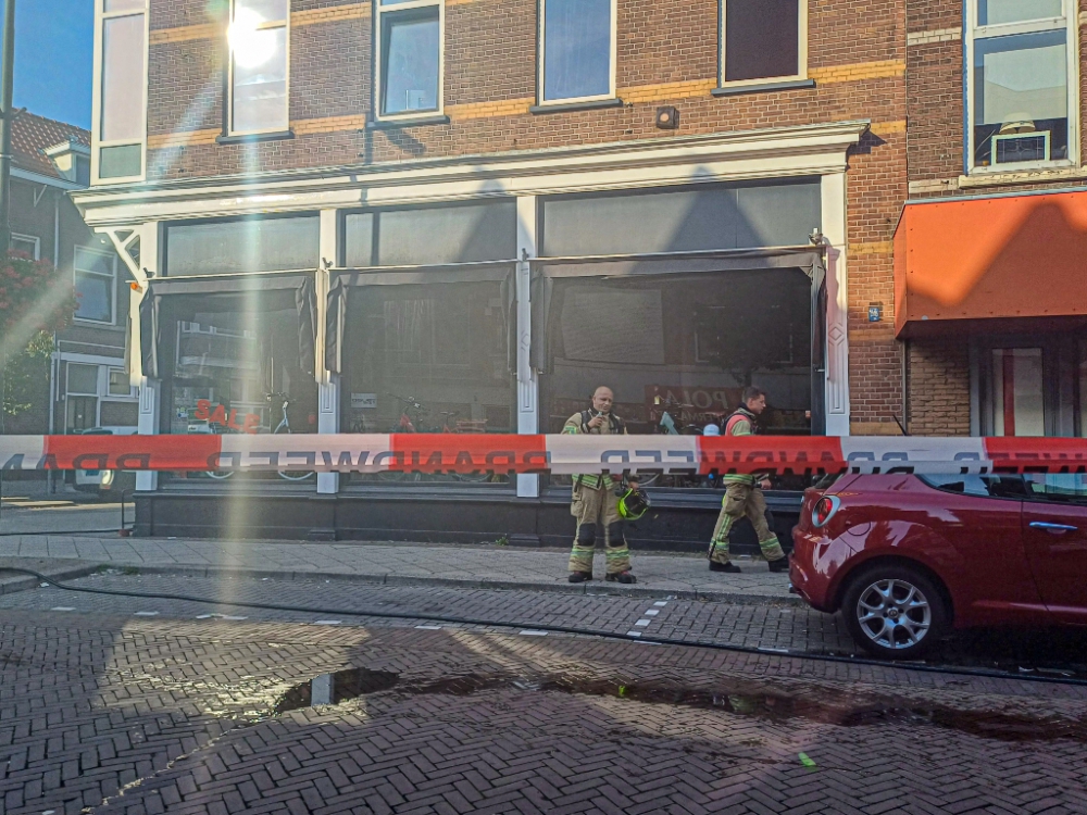 Brand uitgebroken in fietsenwinkel op de Groenelaan, brandweer ramt voordeur in