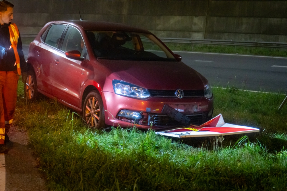 Auto ramt verkeersbord in bocht oprit snelweg