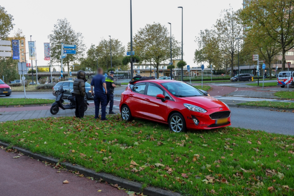 Scooter en auto botsen op rotonde