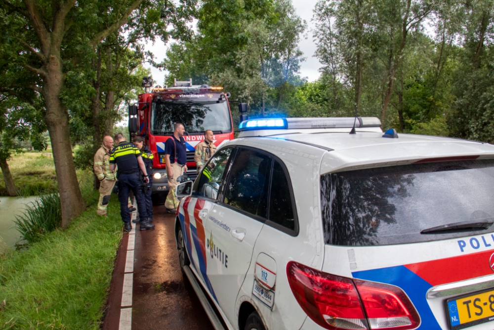 Fietsster valt in water door windvlaag