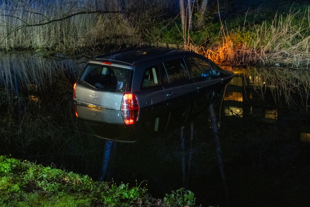 Auto rolt voor ogen eigenaar het water van de Oreliosingel in