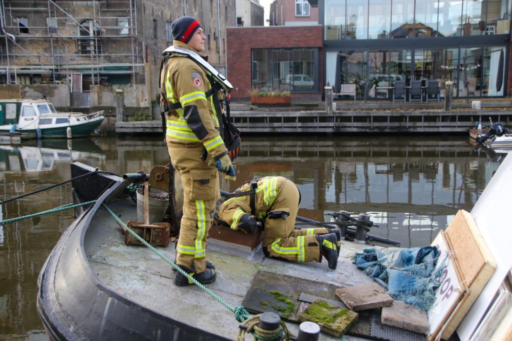 Woonboot raakt lek, brandweer schiet te hulp