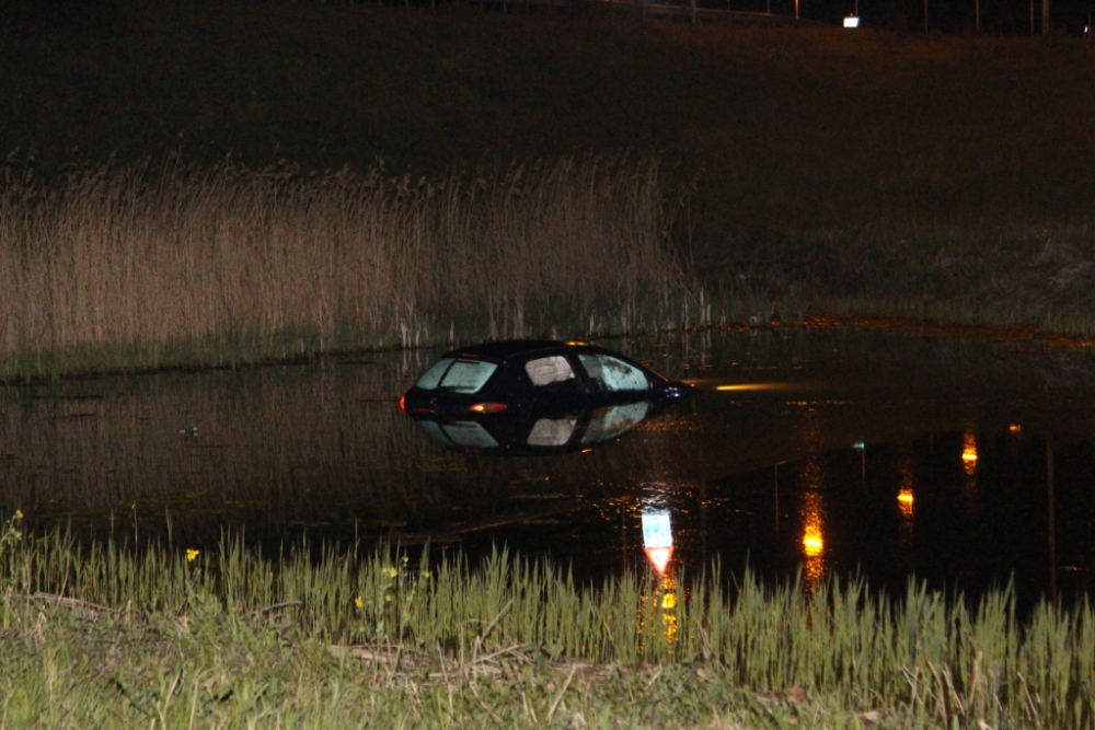 Auto raakt vangrail A20 en duikt in water