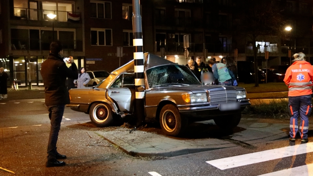 Oldtimer om paal gevouwen na aanrijding in Schiedam