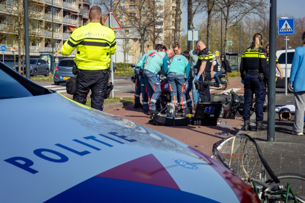 Hulpdiensten behandelen de scooterrijder.