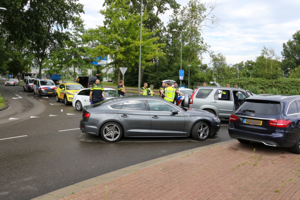 Landelijke eenheid politie rijdt auto klem op rotonde Hargalaan