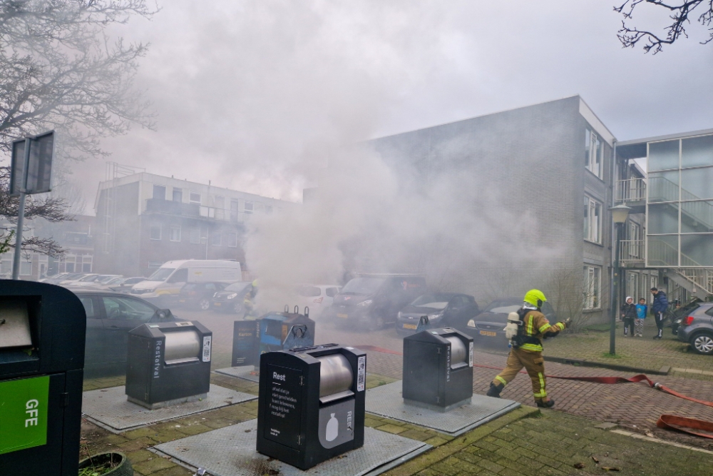 Brandweer blust brandende papiercontainer in Vlaardingen