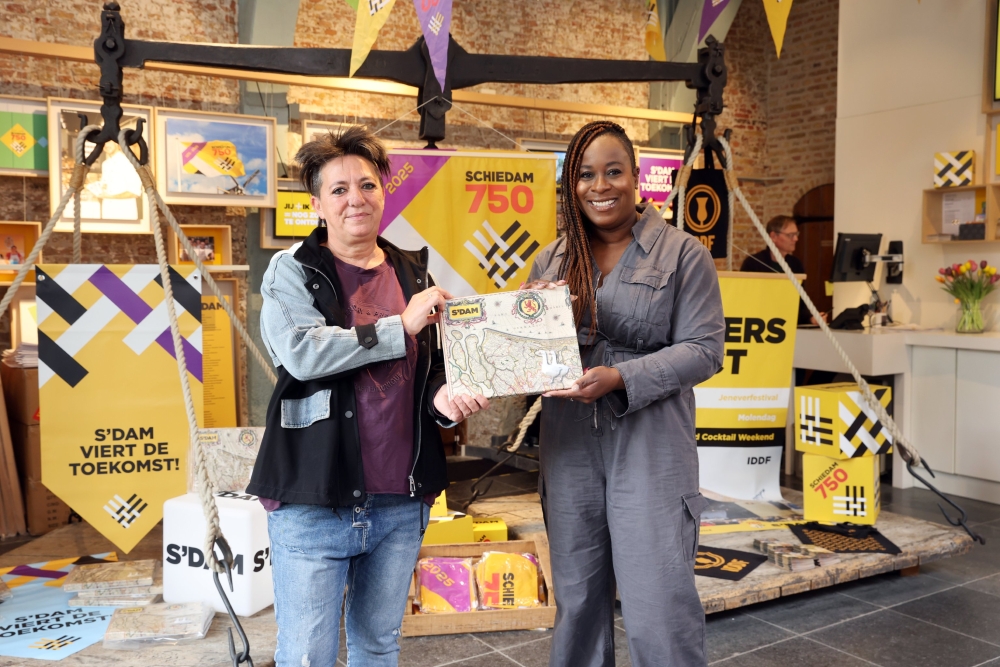 Raadslid Ingrid Coenradie (links) en wethouder Anouschka Biekman ontvangen het eerste exemplaar van het Schiedamse ganzenbord