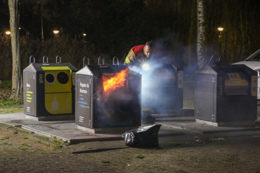 Vlammen slaan uit papiercontainer in Vlaardingen-Ambacht