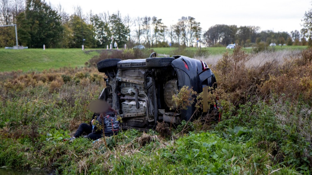 Auto slaat over de kop op Maassluissedijk en belandt aan overkant van sloot