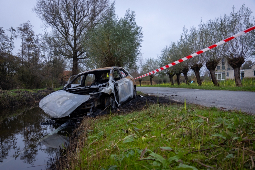 Brandweer vindt auto volledig in brand in sloot met lantaarnpaal eronder