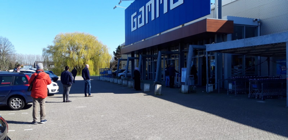 Netjes, met 1,5 meter tussenruimte, in de rij voor bouw- en supermarkt