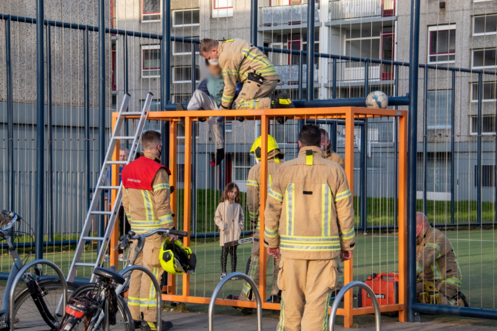 Jongen met voet vast in voetbalkooi