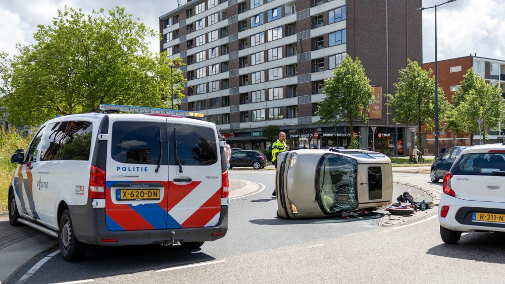 Brommobiel belandt na botsing op z’n kantje op rotonde in Schiedam