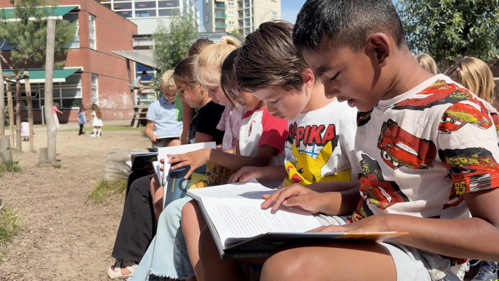 Plein bassischool De Vlinder vol lezende kinderen dankzij boek over Schiedam