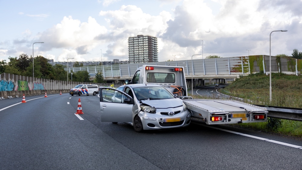 Bocht A20 dicht na ongeluk op Kethelplein, autotransporter eindigt tegen verkeer in