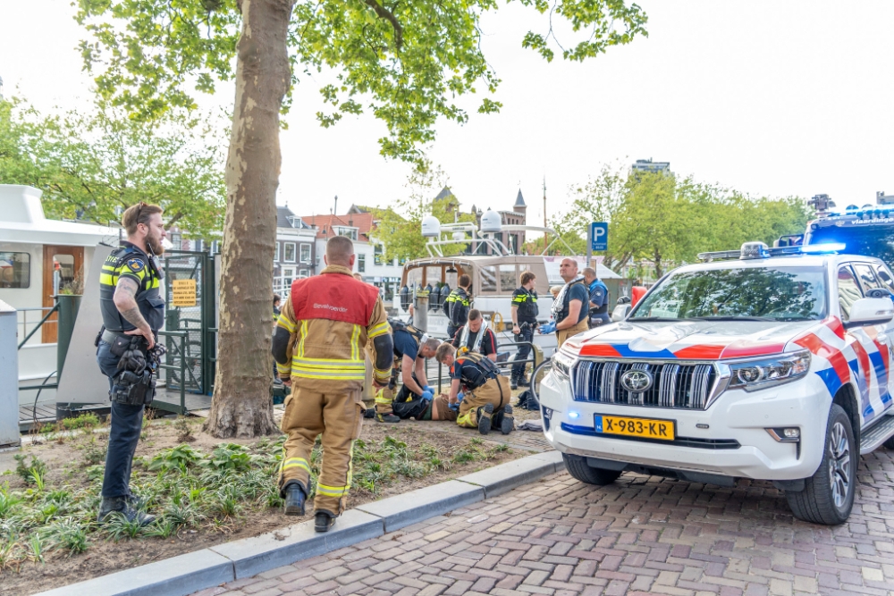 Omstanders en hulpverleners redden man uit water Oosthavenkade