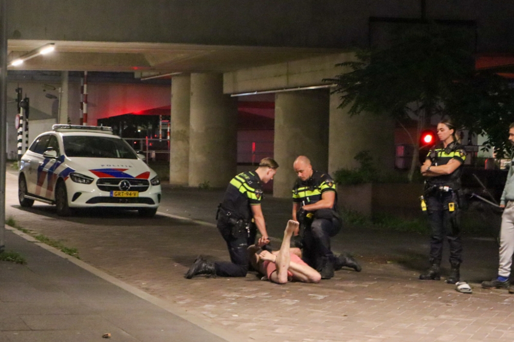 Halfnaakte man breekt spiegels van rijdende auto&#039;s